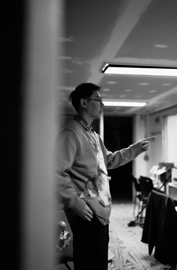 Hua gives direction during a black-and-white rehearsal photograph.