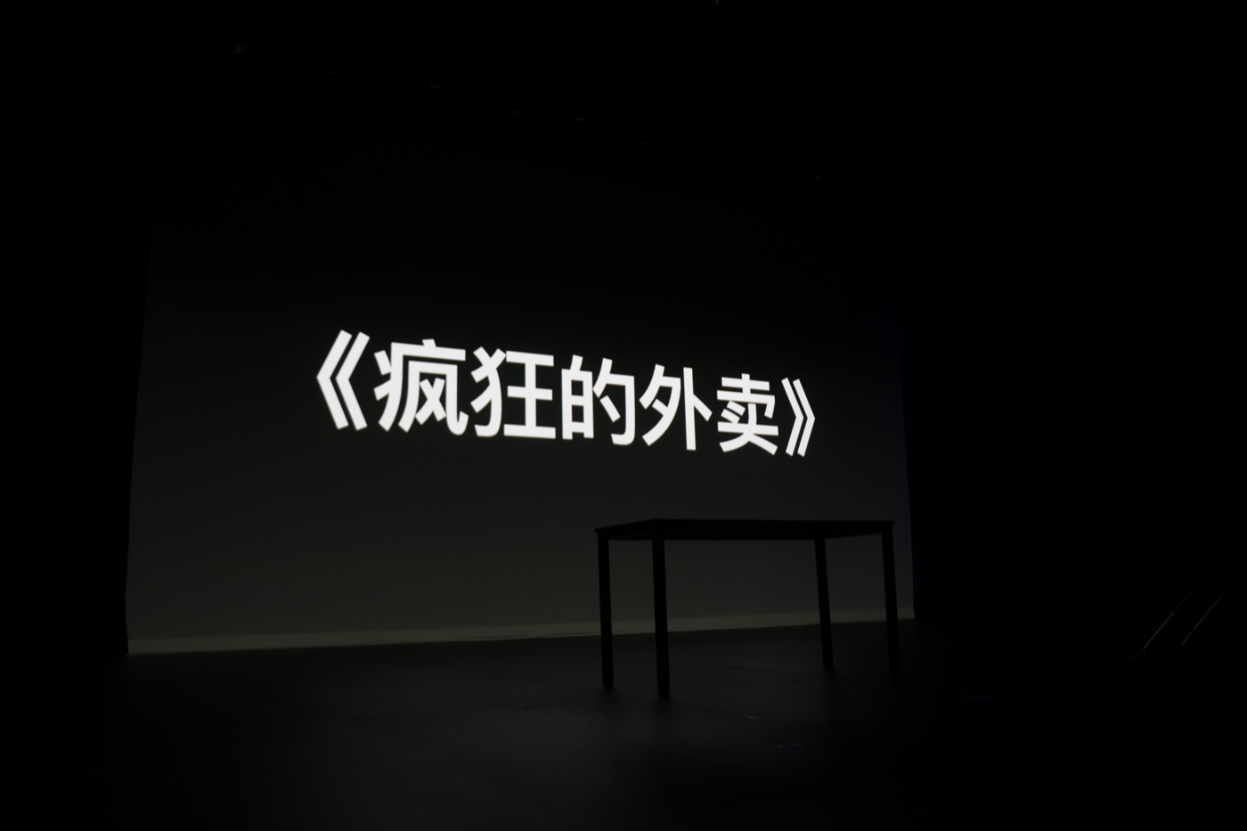 The title Crazy Delivery is projected onto an empty stage before the show.