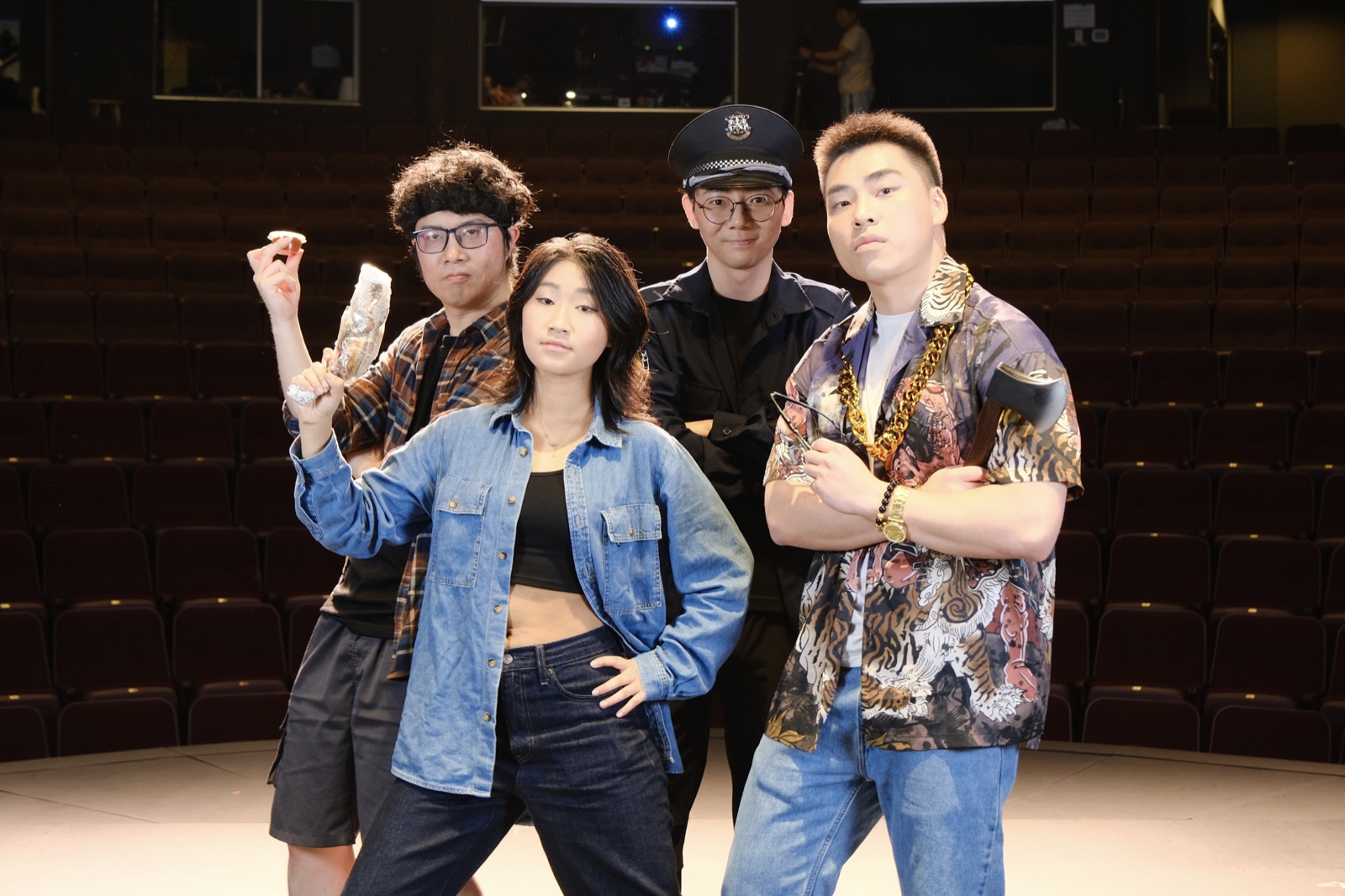 The four-person Crazy Delivery cast poses in costume on an empty stage.
