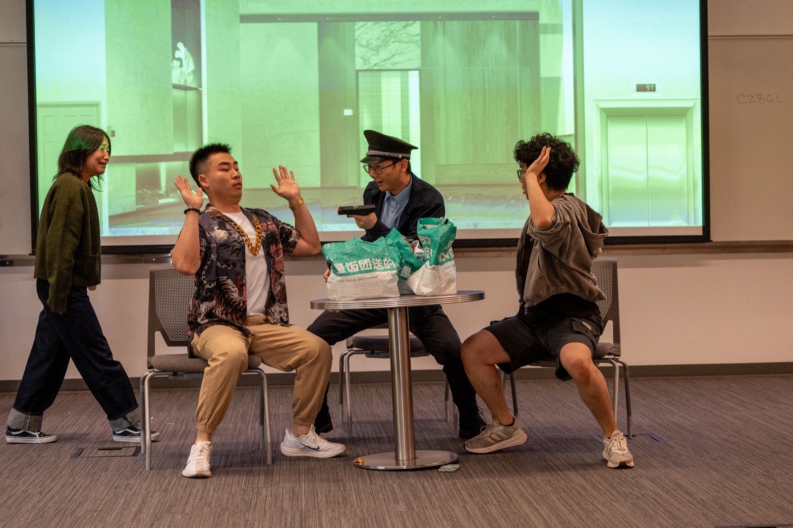 The Crazy Delivery cast rehearses a scene in a classroom.